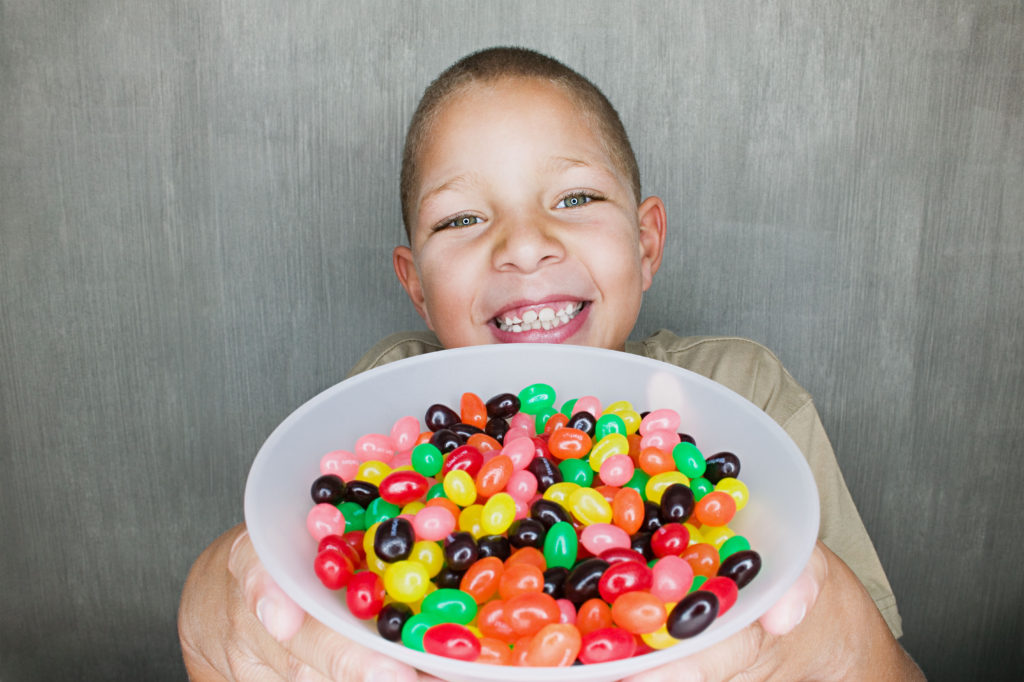 Boy holding bowl of jelly beans Escolas do Bem