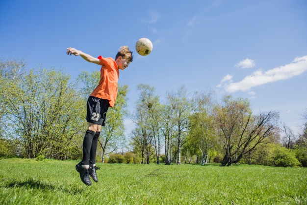 concentrated-boy-hitting-the-ball-with-his-head_23-2147636786