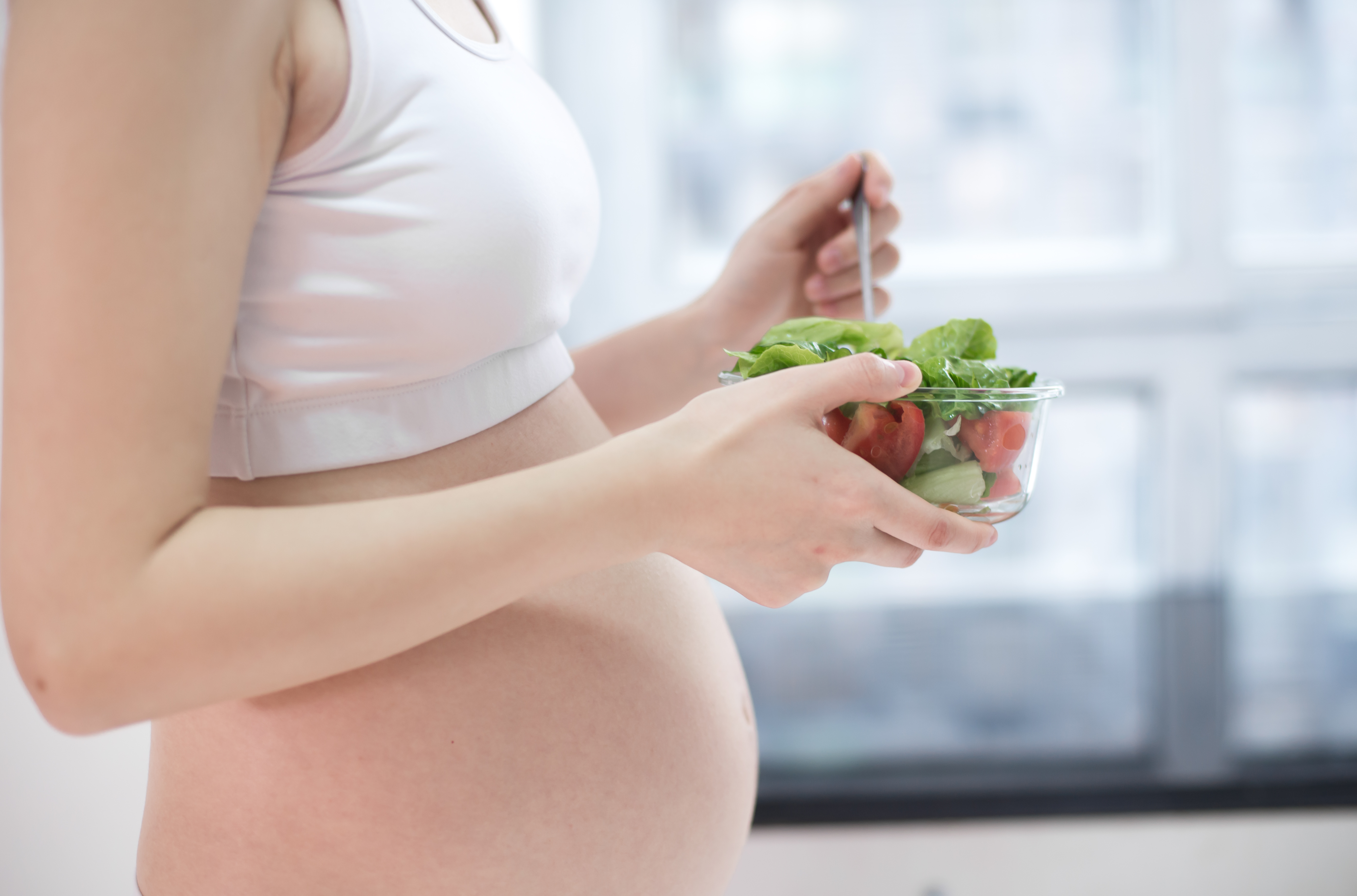 healthy nutrition and pregnancy. pregnant woman's belly and vegetable salad